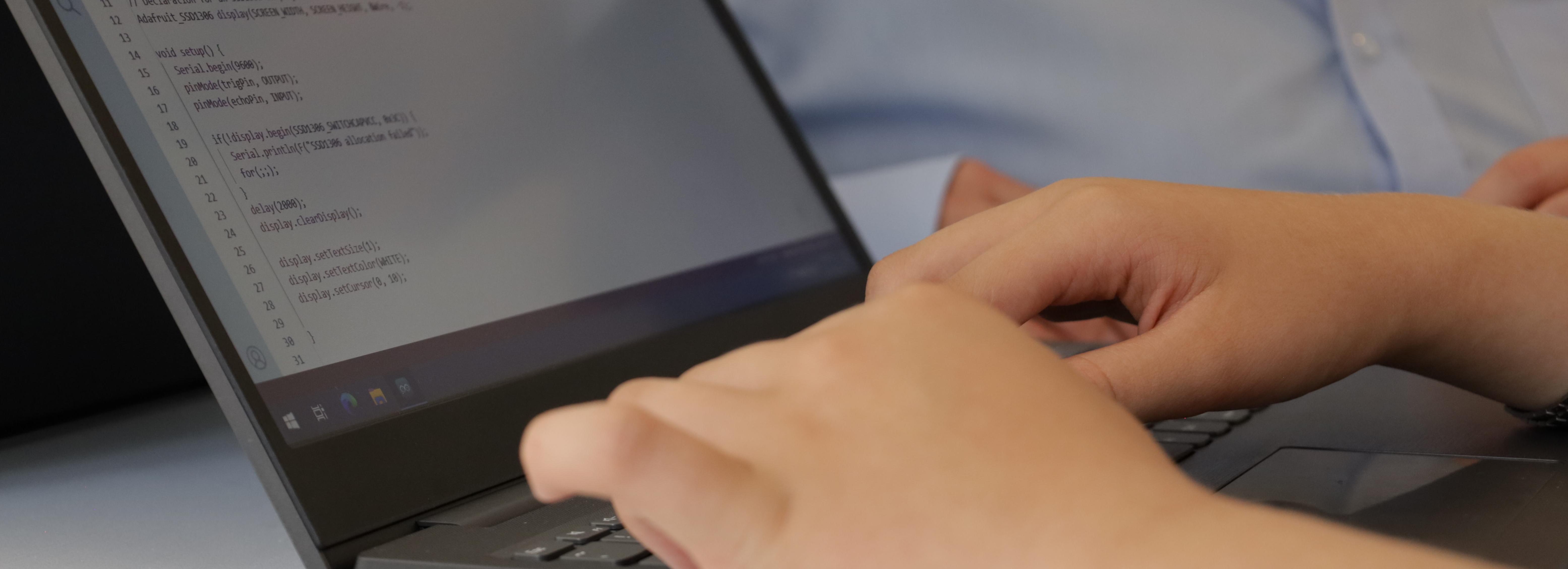 student programming on a laptop